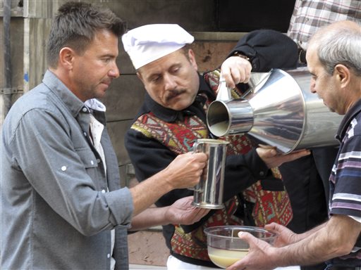 In this April 19, 2014 photo released by the Travel Channel, Jack Maxwell, left, helps deliver the popular fermented beverage boza in Istanbul, Turkey. (AP Photo/Travel Channel)