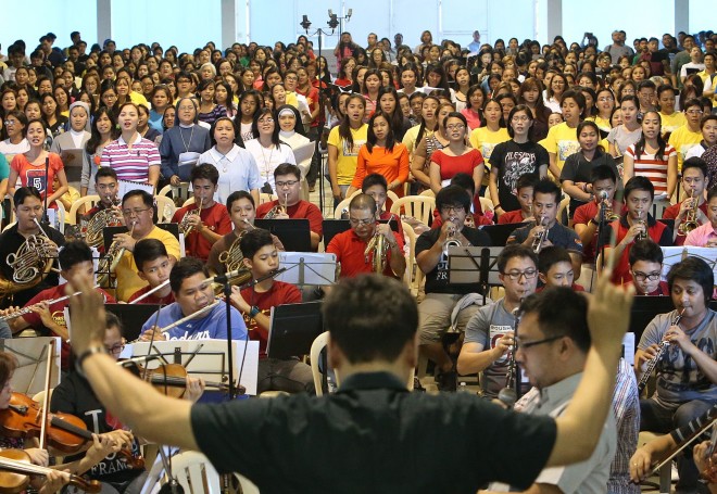 Father Leo Nilo Mangussad conducts the choir and orchestra at rehearsals. Photo by Raffy Lerma