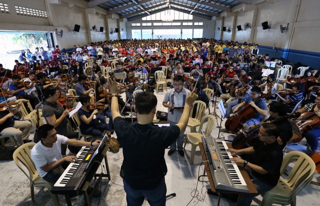 Manoling Francisco, SJ (right, on keyboards), rehearsing with the choir and orchestra. Photo by Raffy Lerma