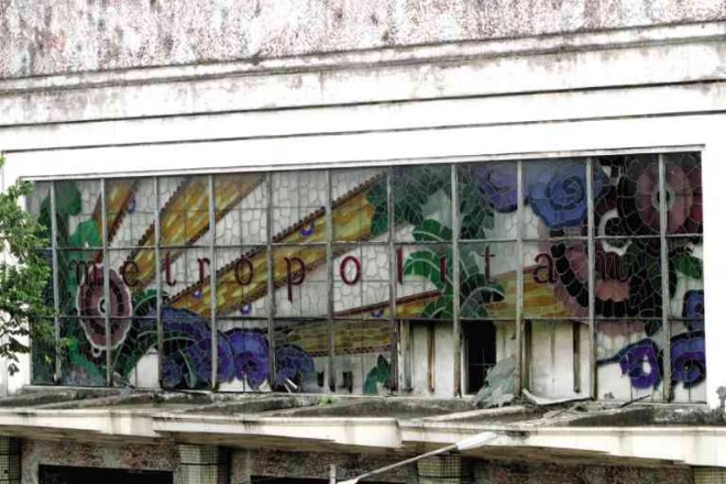 Close up of the stained glass marquee shows several damaged panes in need of renewal.
