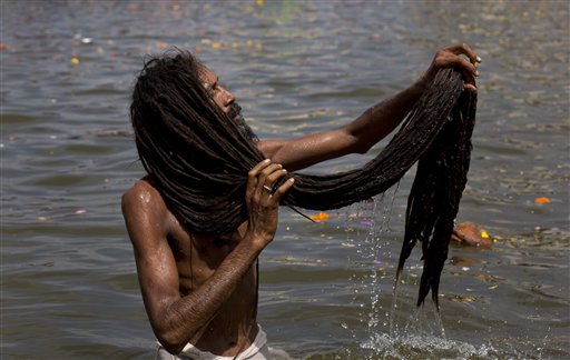 A Hindu holy man takes dips in Godavari River on the first official day of bathing as part of Kumbh Mela, or Pitcher Festival celebrations in Nasik, India, Wednesday, Aug. 26, 2015. Millions are expected to attend this years two-month festival, which began in mid-July and runs until the end of September. (AP Photo/Bernat Armangue)