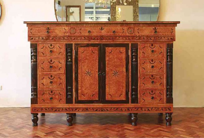 AMBOYNA cabinet shows classical influences.