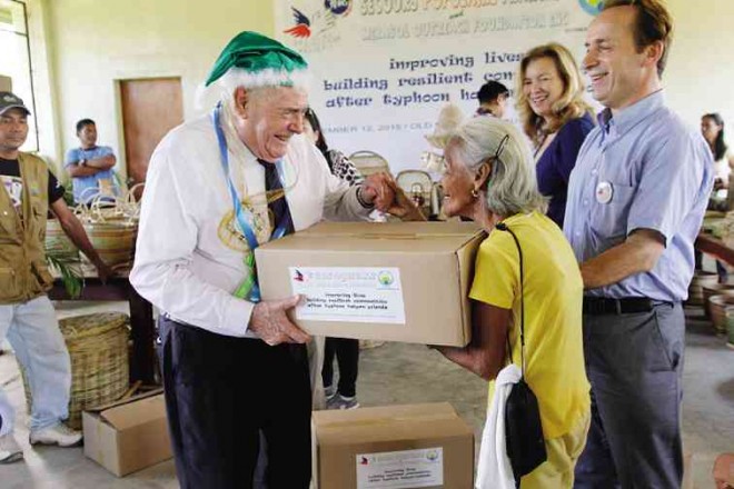 SECOURS Populaire Français president Julien Laupretre plays Santa Claus to a Busuanga resident while French journalist Valerie Trierweiler and SPF national secretary Ismail Hassouneh look on. CONTRIBUTED PHOTO