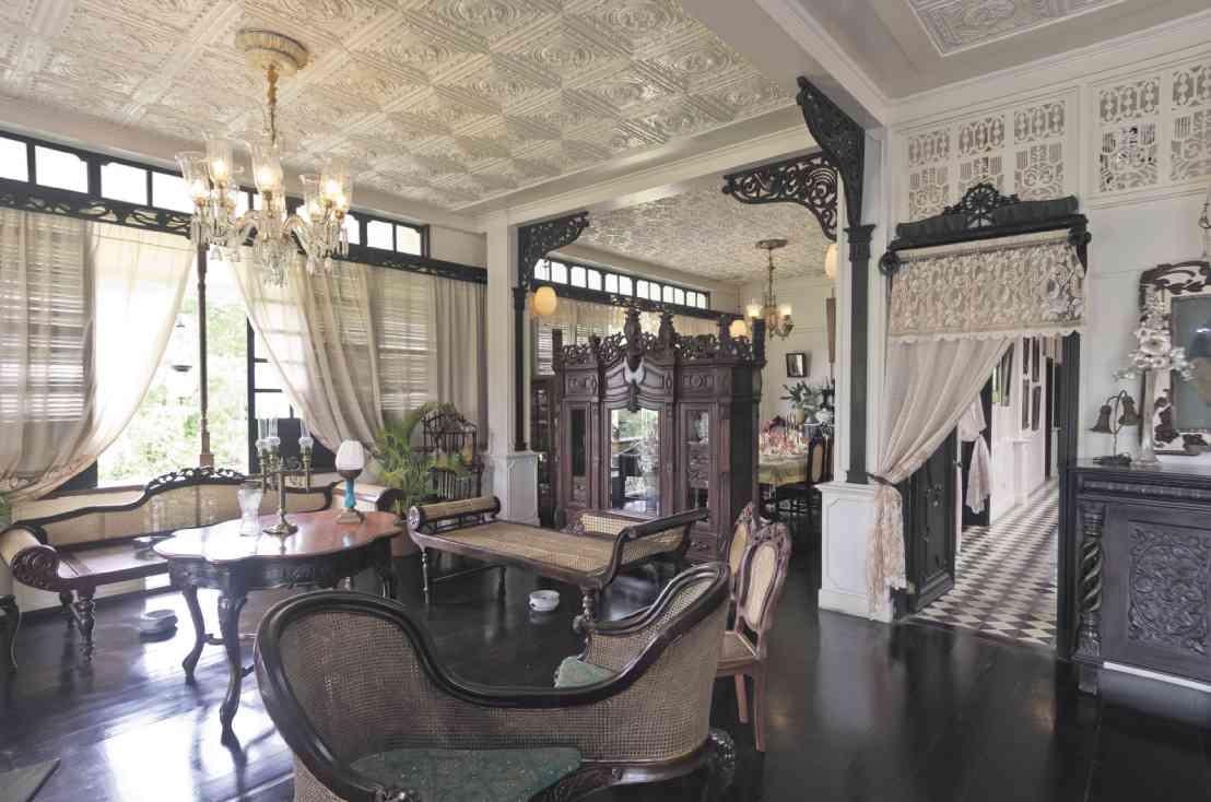 THE LIVING room has bentwood furniture by European maker August Thonet. Carved transoms and corbels from the Gomez house lend graceful lines.