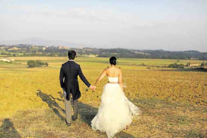 Mr. and Mrs. Semblat walk hand in hand after their wedding in Tuscany.