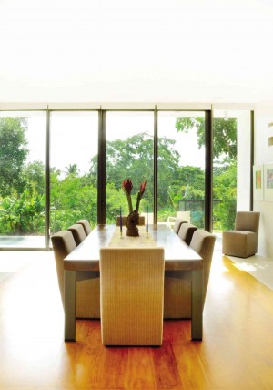THE GLASS panels make the house light, airy and open. The dining area is decked with a hardwood table and chairs by Far East Furniture.