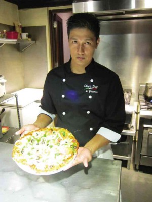 chef Deo presents one of his thin-crust pizzas; seared salmon steak with prawns