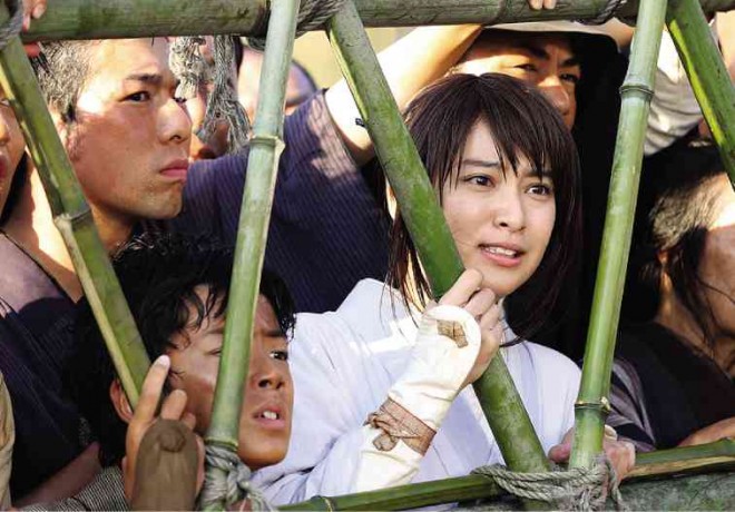 KAMIYA Kaoru (Takei Emi)  watches horrified as Kenshin is sentenced to be beheaded.