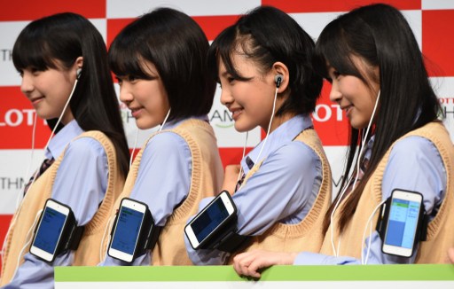 (L-R) Natsumi Matsuoka, Sakura Miyawaki, Haruka Kodama and Rino Sashihara, members of HKT48, a girls pop group pose in a photo session to promote Lotte's prototype "Rhythmi-Kamu", ear phones that count and record the number of times you chew during its press preview in Tokyo on October 21, 2014.  AFP