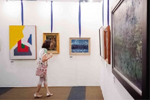 VISITOR views works at Leon Gallery booth.