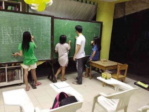 A VOLUNTEER teaches a girl how to multiply double digits. MATTHEW YAP