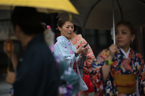 Tourists wearing traditional Japanese long-sleeved kimono, or "furisode," visit Sensoji Buddhist temple at Asakusa district in Tokyo, Saturday, Nov. 8, 2014.  AP