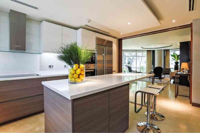 THE KITCHEN with SieMatic systems and high-end appliances is visually connected to the living room with abaca wallpaper.