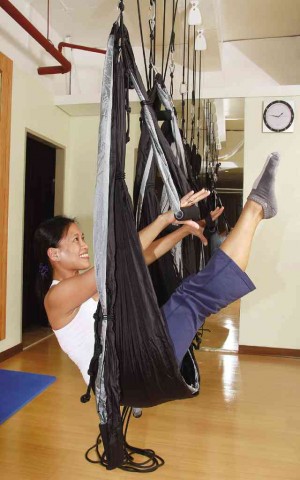 SITTING on the hammock, Camille Joson in a Pilates T-Zer which works burns the stomach muscles without hurting the back