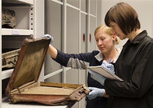 In this undated photo provided by the Auschwitz-Birkenau State Museum employees inspect a victim’s suitcase that is kept in the recently-opened, state-of-the-art protective storage at the Auschwitz Museum in Oswiecim, Poland. AP