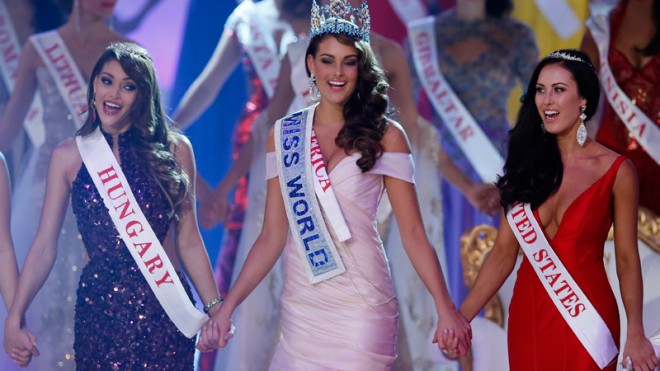 Miss South Africa Rolene Strauss, centre, celebrates after being crowned Miss World 2014, during the finale of the competition at the ExCel centre in London, Sunday, Dec. 14 2014. Miss Hungary Edina Kulcsar, left, came second with Miss United States, Elizabeth Safrit, right, finishing third. (AP Photo/Alastair Grant)