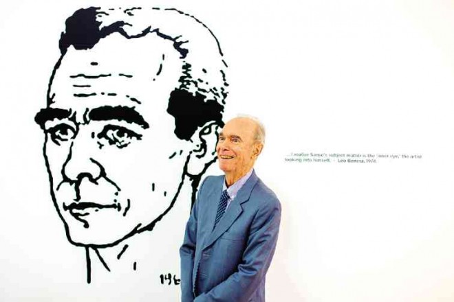 JUVENAL Sansó at Fundacion Santiago, before blown-up sketch of himself that he did in 1964. On the wall is inscription, an excerpt from the late critic Leo Benesa: “I realize that Sansó’s subject matter is the ‘inner eye,’ the artist looking into himself.”