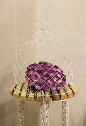 DOME wire cage on top of hydrangeas sitting on a pedestal made of natural wood with wrought iron base