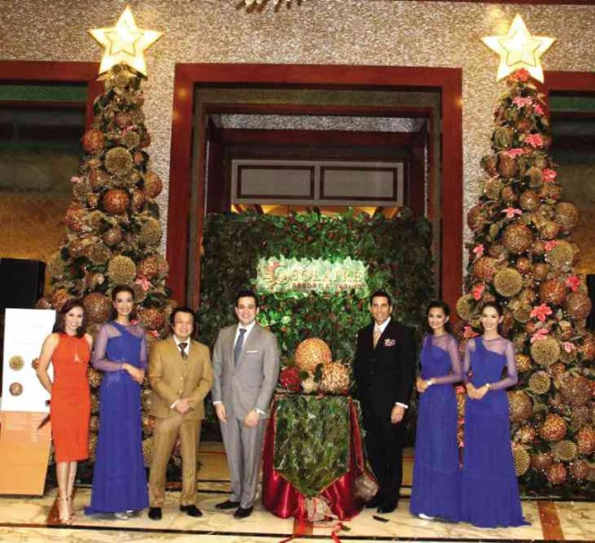 SOLAIRE Resort and Casino president and chief operating officer Thomas Arasi (third from right), with host Issa Litton, vice president for brandmarketing Jasper Evangelista, vice president for hotel operations Gianpietro Iseppi and Solaire ambassadors, unwraps a huge “Gift of Light” at themain lobby as part of Solaire’s annual Christmas tree-lighting ceremony.
