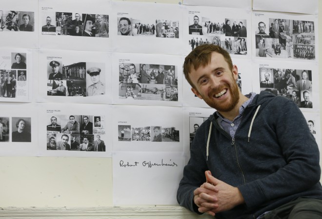 Actor John Heffernan poses with old photographs and a signature of Robert Oppenheimer, at a rehearsal studio in London, Tuesday, Nov. 25, 2014. Heffernan is playing the part of Robert Oppenheimer in a new play the Royal Shakespeare Company is doing about the physicist, who led the team that developed the first nuclear weapon. AP