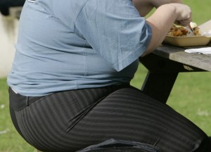 FILE - In this Wednesday, Oct. 17, 2007 file photo, an overweight person eats at a bench in London. AP