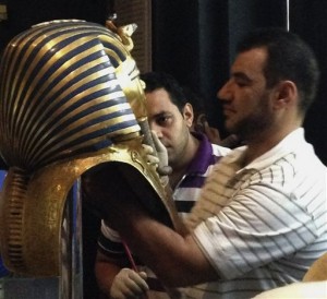 In this Aug. 12, 2014, photo provided by Jacqueline Rodriguez, a man glues the beard part of King Tutankhamun's mask back on at the Egyptian Museum in Cairo, Egypt. The blue and gold braided beard on the burial mask of famed pharaoh Tutankhamun was hastily glued back on with epoxy, damaging the relic after it was knocked during cleaning, conservators at the museum in Cairo said Wednesday, Jan. 21, 2015. AP
