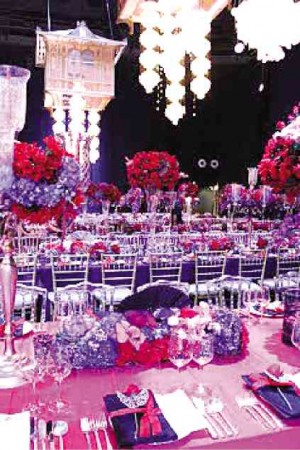 OTHER tables were decorated with low floral centerpieces so guests could see and talk to those seated across the table. The production team stuck to a motif of red and black accented by clear glass and crystalline chairs.