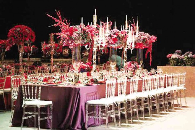 FLORAL centerpieces perched on clear glass vases provide unobstructed views for guests. The Tiffany Ghost chairs mimic the theme.
