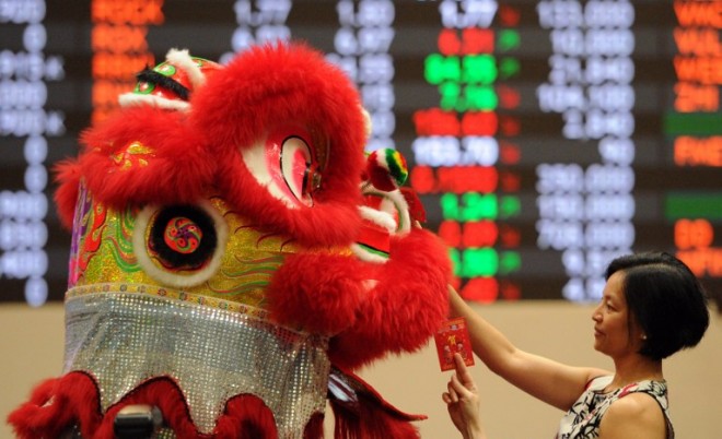 A performer donning a lion dance costume, tries to pick up red "lai see" envelopes from employees at the Philippine stock exchange during Lunar New Year of the Sheep celebrations in Manila on February 18, 2015. The Lunar New Year, the most important holiday in China and a number of countries in east and southeast Asia, starts on February 19 bringing in the "Year of the Sheep".   AFP