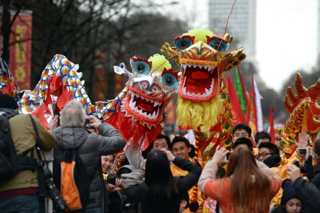 People take pictures of giant dragons as they are carried in the streets during the Chinese New Year celebrations in the 13th district of Paris, on February 9, 2014. AFP