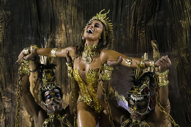 Actress Juliana Paes is carried by dancers of the Viradouro samba school in the Carnival parade at the Sambadrome in Rio de Janeiro, Brazil, Sunday, Feb. 15, 2015. The skies opened up about an hour ahead of the start of the all-night-long extravaganza, drenching revelers and flooding streets near the Sambadrome. (AP Photo/Felipe Dana)