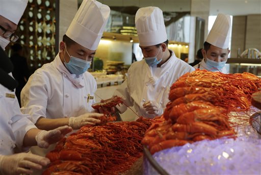 In this Feb. 9, 2015, photo, Chinese chefs prepare Boston lobsters at the Auspicious Garden restaurant in Pangu Seven Star Hotel in Beijing. Every morning the restaurant in Beijing receives 800 lobsters that have just crossed the Pacific aboard a cargo plane. In the evening, hundreds of diners fill the two-story restaurant in the gigantic hotel for a nearly $80 all-you-can-eat buffet with the New England specialty as the main attraction. AP
