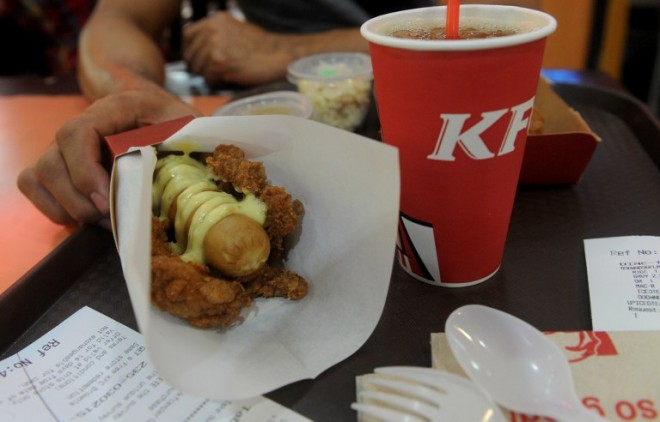 A man prepares to eat a "Double Down Dog," in Manila on February 3, 2015, a product conceived and introduced by the Philippine franchise of KFC. Fastfood giant KFC in the Philippines has begin selling a hotdog wrapped in fried chicken instead of bread and covered in cheese sauce to the horror of dieticians and amusement of social media users. AFP PHOTO / Jay DIRECTO