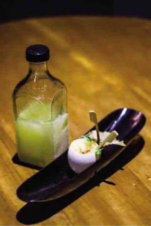 “KWATRO Kantos”:A chilled bottle of gin infused with preserved calamansi is presented alongside a chicken meatball marinated in soy, ginger and garlic, and nestled in an eggshell with Mandarin orange foam and salmon roe.