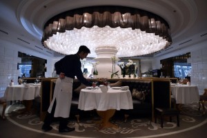 A member of staff lays a table in Les Menus restaurant in Moscow on Monday, March 23, 2015. Michelin three star chef Pierre Gagnaire will close his gourmet restaurant, Les Menus, opened in 2010.  AFP PHOTO/KIRILL KUDRYAVTSEV
