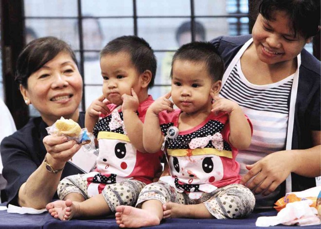 SEPARATE LIVES  Separated conjoined twins Jennylyn and Jerrylyn de Guzman are presented to the media during a press conference at the Tzu Chi Foundation in Quezon City. The twins underwent surgery in Taiwan with the help of the foundation. With them are their mother Ludy (right) and Tzu Chi volunteer Conchita Tan. RICHARD A. REYES