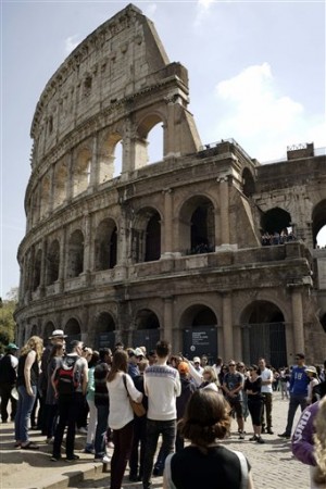 In this photo taken on Friday, April 10, 2015, people line up to enter the Colosseum, in Rome. Vacations in Europe have a new attraction: the euro's steep drop in value is making the continent much cheaper for tourists from across the world, especially the United States and China. AP