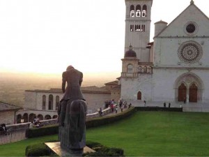 WITH THE STATUE of a bowed Francis in the foreground, the basilica sits in the Umbrian sunset.