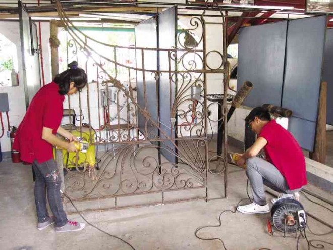 students from Escuela Taller working on grillwork