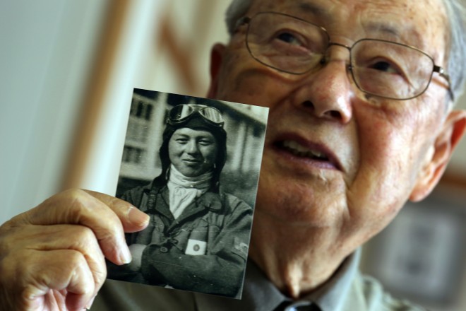 In this April 23, 2015 photo, Hisashi Tezuka, a kamikaze who survived because the war ended, holds a picture of himself as a kamikaze pilot in 1945 during exclusive interview with the Associated Press at his home in Yokohama, south of Tokyo. He was the kamikaze, the divine wind, ordered to fly their planes into certain death. The U.S. Strategic Bombing Survey and data kept at the library at Yasukuni shrine in Tokyo estimate that about 2,500 of them died during the war. Some history books give higher numbers. About one in every five kamikaze planes managed to hit an enemy target. (AP Photo/Eugene Hoshiko)