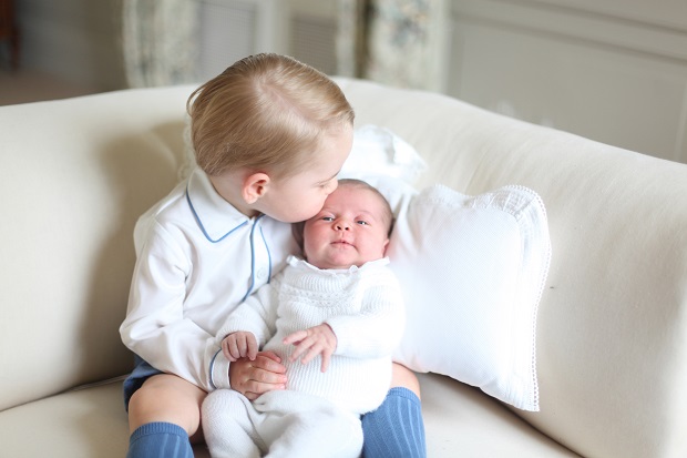 CORRECTS LOCATION - This image made available by Kensington Palace Saturday, June 6, 2015, taken by Kate, Duchess of Cambridge, at Anmer Hall, eastern England in mid-May 2015 shows Britain's Princess Charlotte, right, being held by her brother, 2-year-old, Prince George. Britains royals have been photographed by some of the world's leading photographers. But Prince William and Kate are continuing a more informal tradition begun two years ago with the first official portrait of Prince George, taken by his grandfather Michael Middleton. Charlotte was born May 2 and is fourth in line to the throne. (Duchess of Cambridge via AP)  MANDATORY CREDIT