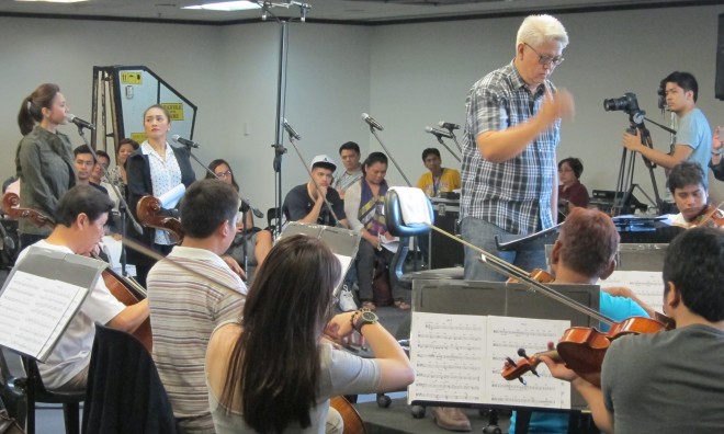 Alejandro and Ampil  (back left, standing) rehearse songs with the orchestra. PHOTO BY FRAN KATIGBAK