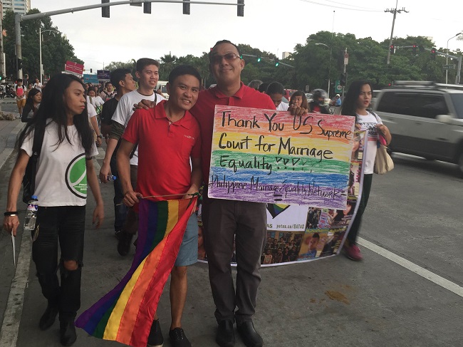  A couple holds a rainbow colored placard which expresses gratitude to the Supreme Court of the United States for its decision favoring same sex marriage. Photo by Marc Jayson Cayabyab