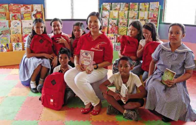 NATIONAL Book Store Foundation, Inc. president Xandra Ramos-Padilla with Pawing Elementary School students
