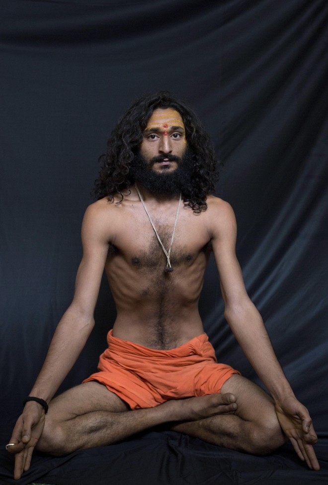 In this Friday, June 12, 2015 photo, Bhrahaspati Bharti Baba, an Indian Hindu holy man, demonstrates the yoga pose Ardha Padmasana, or the half Lotus, where the legs are crossed and foot rests on the thighs, in Gauhati, India. Sunday marks the first International Yoga Day, which the government of India Prime Minister Narendra Modi is marking with a massive outdoor New Delhi gathering. (AP Photo/Anupam Nath)