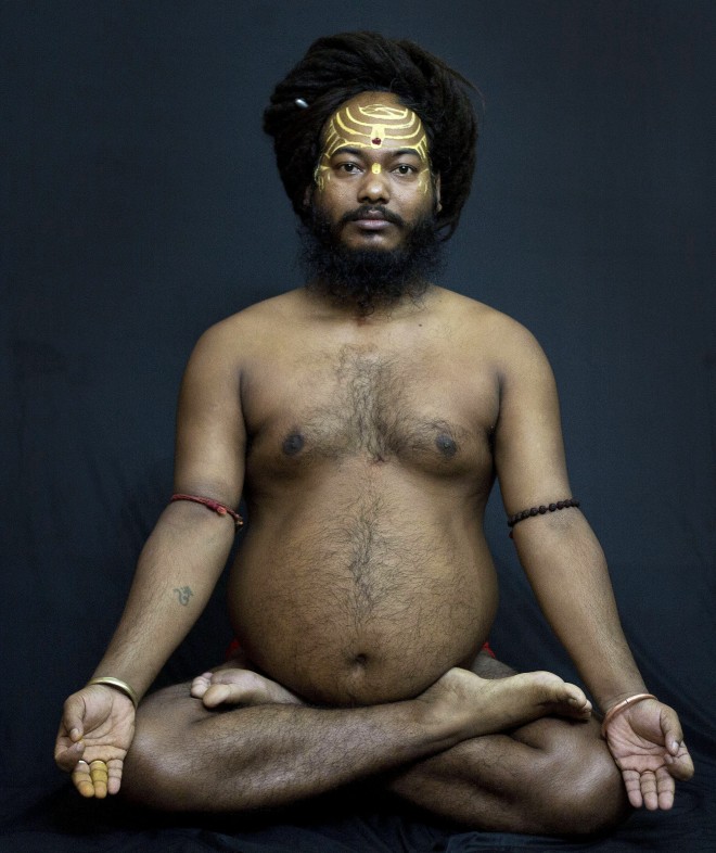 In this Friday, June 12, 2015 photo, Mahant Ranjitanand Giri Maharaj, an Indian Hindu holy man, demonstrates the yoga pose, Padmasana, or the famed Lotus, where the legs are crossed and the feet rest on the thighs, in Gauhati, India. Sunday marks the first International Yoga Day, which the government of India Prime Minister Narendra Modi is marking with a massive outdoor New Delhi gathering. (AP Photo/Anupam Nath)