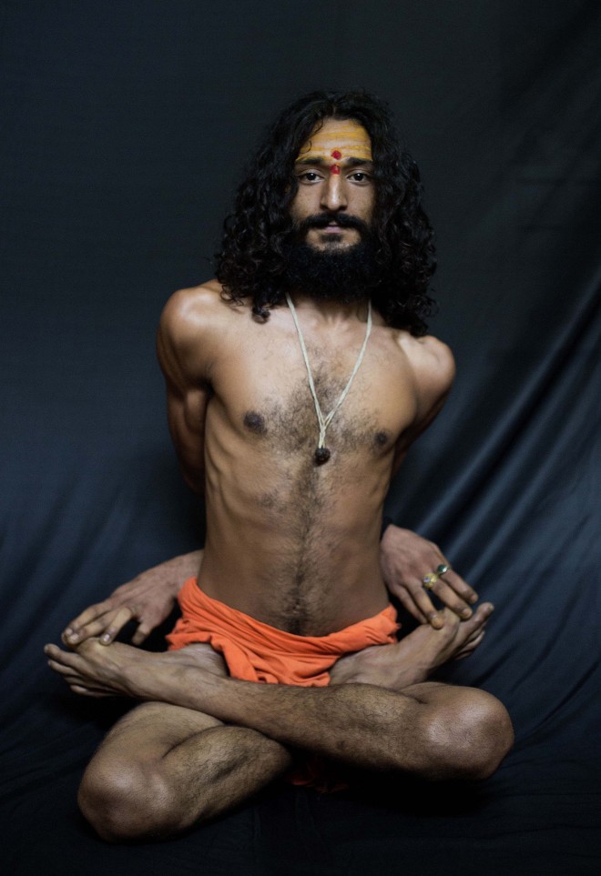 In this Friday, June 12, 2015 photo, Bhrahaspati Bharti Baba, an Indian Hindu holy man, demonstrates the yoga pose Baddha Padmasana, or Locked Lotus pose, where the arms are twisted around the back, in Gauhati, India. Sunday, June 21, marks the first International Yoga Day, which the government of Prime Minister Narendra Modi is marking with a massive outdoor New Delhi gathering. (AP Photo/Anupam Nath)