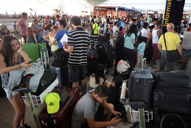 Travellers wait as flights are cancelled due to the eruption of Mount Raung in East Java, at Ngurah Rai International Airport in Bali, Indonesia, Sunday, July 12, 2015. Ash spewing from the volcano on Indonesia's main island of Java sparked chaos for holidaymakers as airports closed and international airlines canceled flights to andm from tourist hotspot Bali, stranding thousands. AP