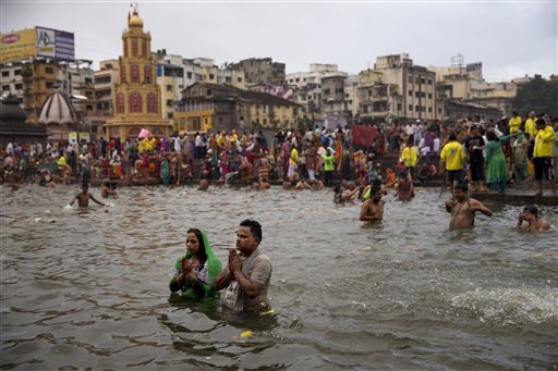 Indian pilgrims offer prayers as they perform rituals in the Godavari River during Kumbh Mela, or Pitcher Festival, in Nasik, India, Wednesday, Aug. 26, 2015. Hindus believe taking a dip in the waters of a holy river during the festival will cleanse them of their sins. Wednesday marked the first day of bathing for those attending this years festival on the banks of the Godavari River in Maharashtra state. (AP Photo/Tsering Topgyal)