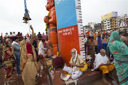 Hindu pilgrims offer prayers to an idol of monkey God Hanuman as they gather next to the Godavari River during Kumbh Mela, or Pitcher Festival, celebrations in Nasik, India, Wednesday, Aug. 26, 2015. Millions are expected to attend this years two-month festival, which began in mid-July and runs until the end of September. (AP Photo/Bernat Armangue)